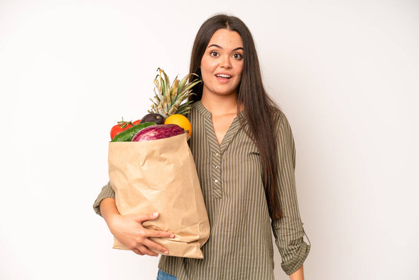 hispanic pretty woma feeling happy and pointing to self with an excited. market vegetables bag concept - Foto, imagen