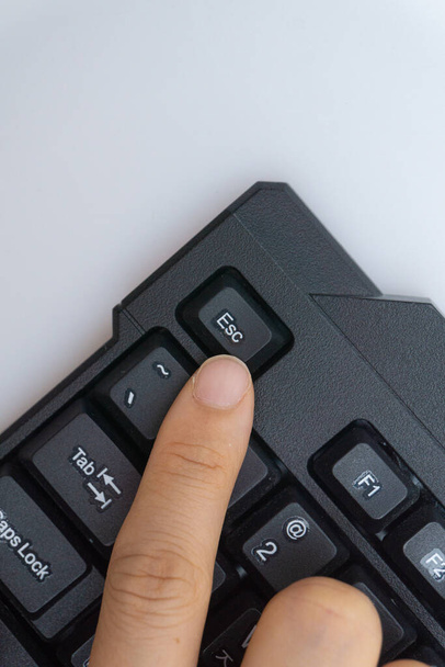 A woman's finger holding a computer keyboard - Zdjęcie, obraz