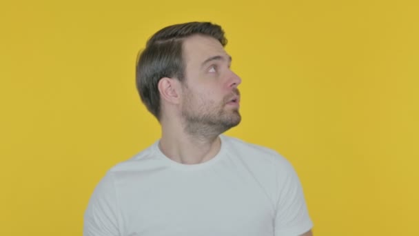 Casual Young Man Feeling Scared, Frightened on Yellow Background  - Filmati, video