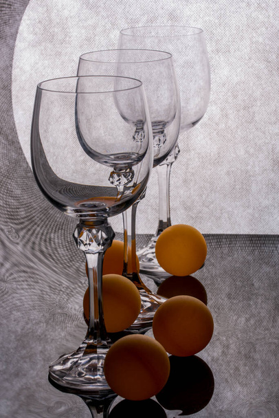 Still life with glass glasses and orange balls - Foto, imagen