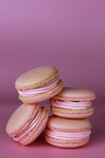 macaroons with pink buttercream on a purple background with copy space - 写真・画像