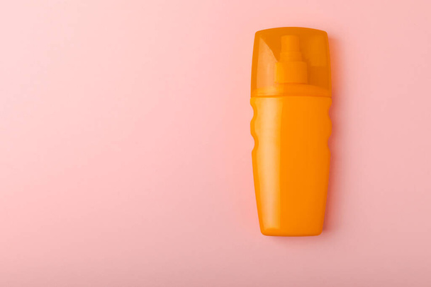 Sunscreen on a pink background. Plastic bottle of SPF sunscreen. Sunscreen selection.Summer travel beach flat lay composition, banner. Summer vacations and spf uv-protecting skin care concept. - Foto, afbeelding