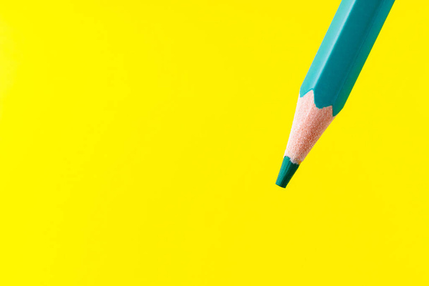 Цветной карандаш крупным планом с выборочным фокусом на стилусе и размытым желтым фоном. Копирование текста. - Фото, изображение