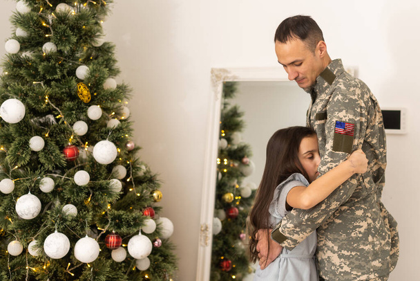 Kızıyla birlikte üniformalı bir asker. İzinli bir asker Noel tatilini ailesiyle evde geçiriyor. - Fotoğraf, Görsel