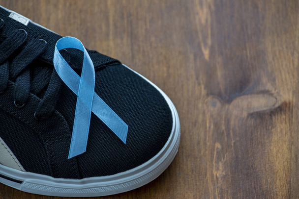 Blue prostate cancer awareness ribbon on black shoes - Foto, Imagem