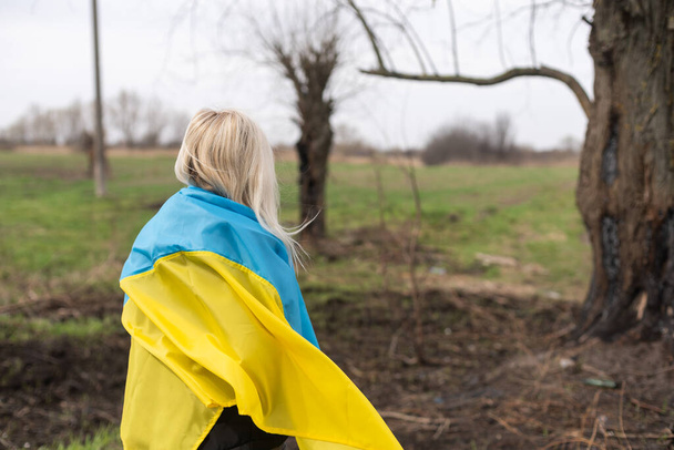 drapeau femme d'ukraine près d'un arbre brûlé. - Photo, image