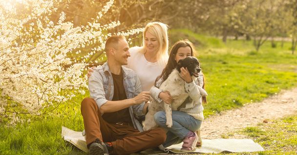 Famiglia felice con cane in giardino
 - Foto, immagini