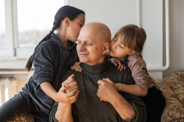 Ukraiński dziadek i dwie wnuczki przytulanie. - Zdjęcie, obraz