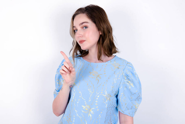 No sign gesture. Closeup portrait unhappy young caucasian woman wearing blue T-shirt over white background raising fore finger up saying no. Negative emotions facial expressions, feelings. - Fotografie, Obrázek