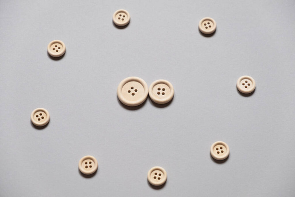 wooden buttons on a gray background. Two buttons in the center. Circle of buttons. The symbol of the family in society. Aggression and protection of the family. - Fotó, kép