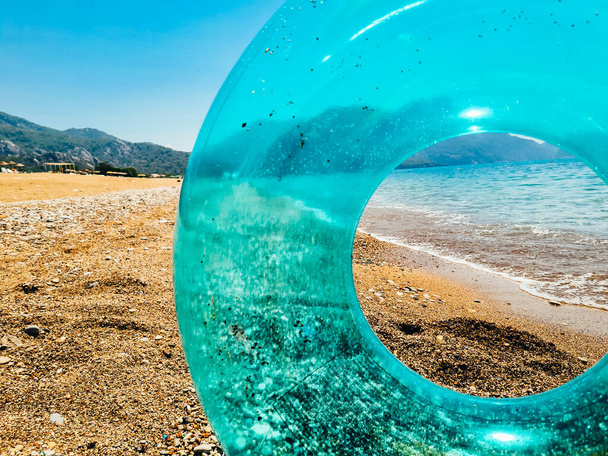 Blue inflatable swim ring float on the beach. Summer vocations concept. - Foto, afbeelding