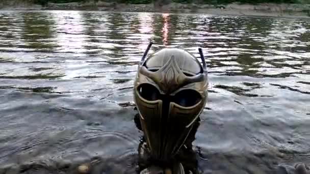 Metaforyczna instalacja na górskiej rzece z kaskiem gladiatorskim - Materiał filmowy, wideo