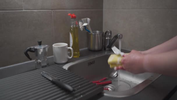 House cleaning, household chores. Washing dishes and kitchen utensils in kitchen sink. Female hand washing dishes at home. Using too much water. Concept of unsustainable resource consumption - Filmagem, Vídeo