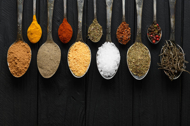 Colorful various herbs and spices for cooking on dark wooden rustic background - Foto, imagen