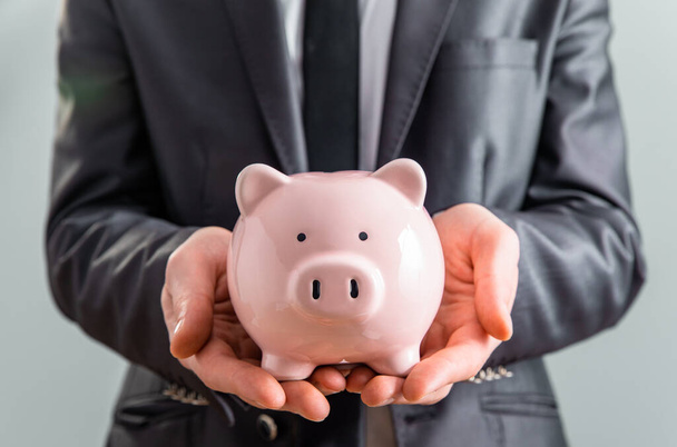 Young business man with piggy bank - Photo, Image