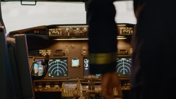African american captain inserting destination coordinates to help pilot before takeoff, flying airplane with dashboard command. Using control panel buttons, windscreen compass and radar. - Filmmaterial, Video