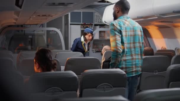 Group of diverse passengers boarding on airplane seats, talking to flight attendant on airline service. Flying and travelling with commercial airline, chatting with stewardess about service. - Imágenes, Vídeo