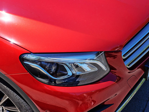 Fragment d'une nouvelle voiture de sport rouge vif avec un phare au xénon - Photo, image