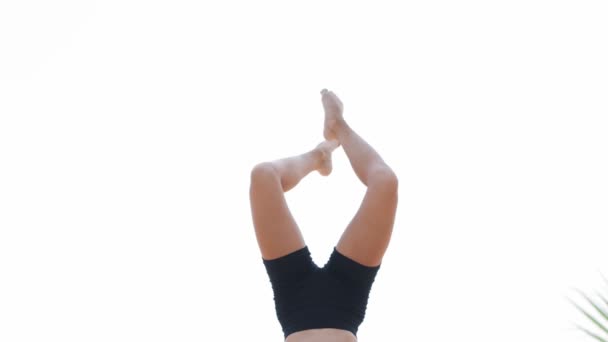 A young woman gymnast balances on her strong hands and moving her hands. Mid shot - 映像、動画