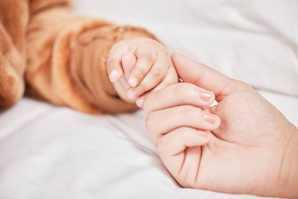 Will you always stay little. a mother holding her sons hand while he sleeps - Foto, imagen