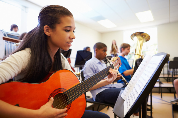 Female Pupil Playing Guitar In Orchestra - Photo, image