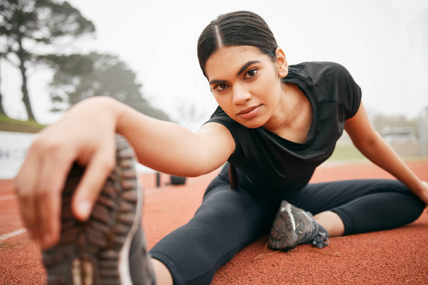 Believe in your potential. an athletic young woman stretching while out on the track - Foto, Imagem