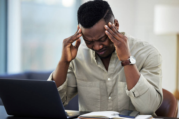 This is too much for one day. a young businessman suffering from a headache while working from home - Fotó, kép