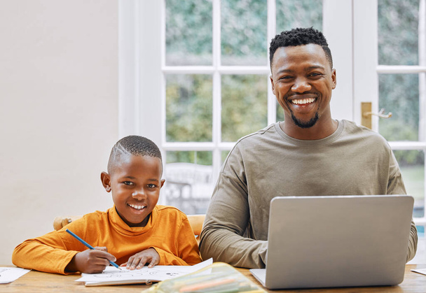 Weve both got work to do. a young father using a laptop while his son does homework at home - Foto, Imagen
