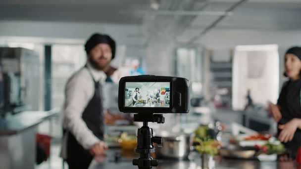 Fotoaparát natáčí lidi vařící profesionální menu v kuchyni, nahrává online vlog pro gastronomii show program v televizi. Tým kuchařů učí gurmánské přípravy jídla. Trojnožka. - Fotografie, Obrázek