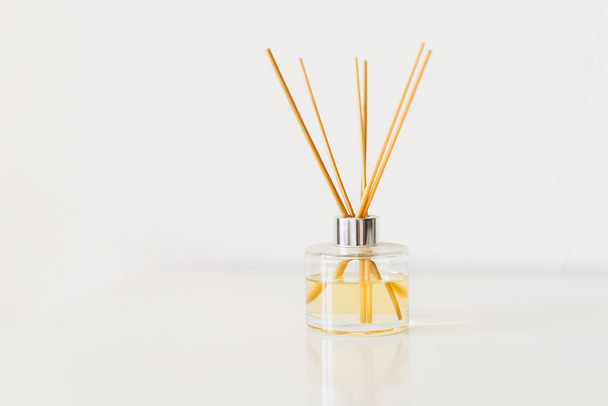 Spa therapy, aromatherapy. Diffuser bottle on a white background. Incense sticks for the home with a floral scent. The concept of eco-friendly fragrance for the home - Foto, imagen