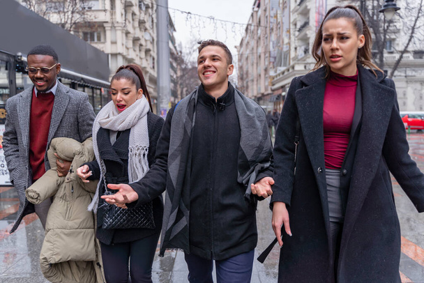 Four multiracial busienss people are walking on the rain together while talking about the company plans, close up - Fotó, kép