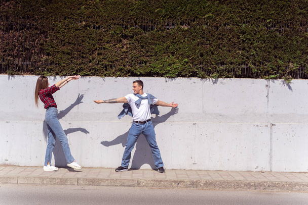 Niedliches Paar tappt auf der Straße in der Nähe der Mauer - Foto, Bild