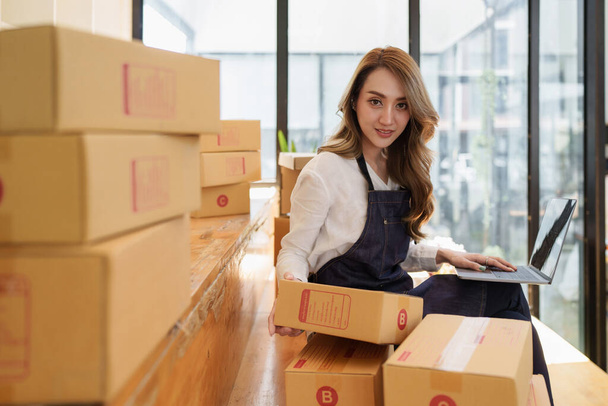 Young Asian woman at warehouse to delivery to Entrepreneur owner SME. Business digital online SME small business and online shop - Фото, зображення
