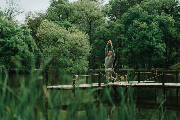 Przystojny chłopiec stojący na moście rozciągającym się w parku - Zdjęcie, obraz