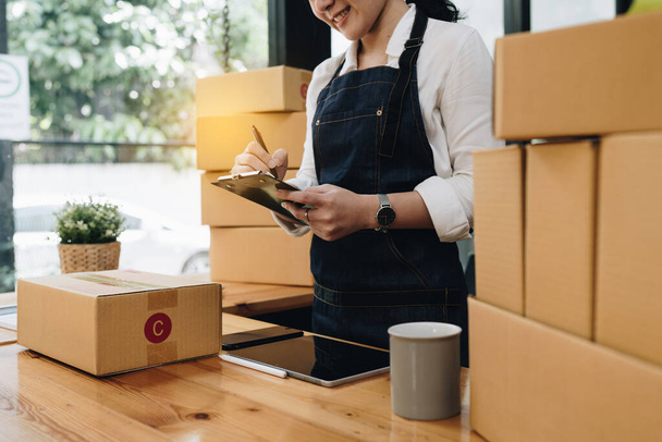 Attractive Asian SME business woman checking order at warehouse - Photo, Image