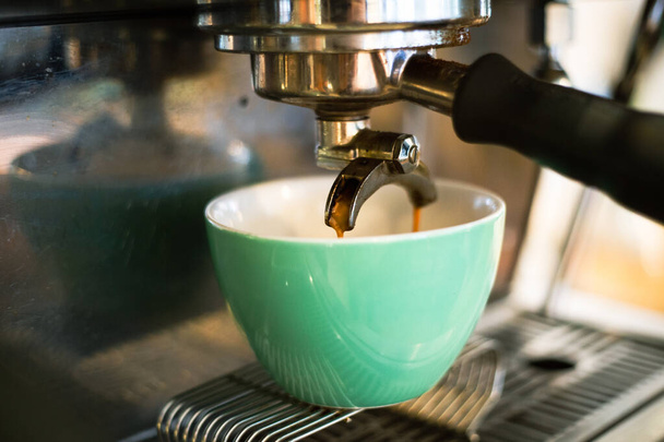 A Close-up shot of espresso pouring from coffee machine into cup - Фото, зображення