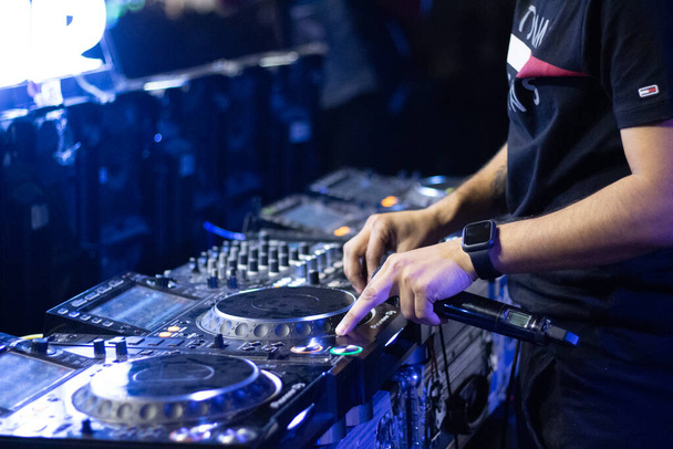 Un gros plan d'un DJ grooving lors d'une fête et un micro dans sa main avec quelques belles lumières à Delhi, en Inde - Photo, image