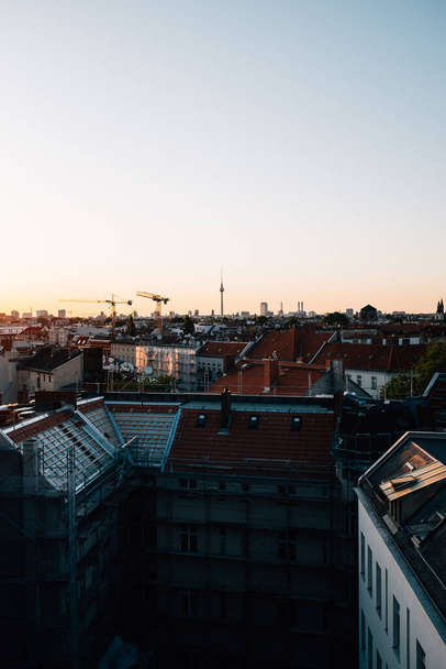A vertical shot of a cityscape under a sunset sky - Fotoğraf, Görsel