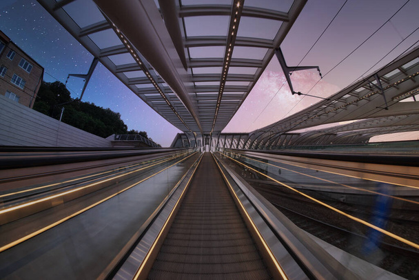 A low angle shot of an escalator against buildings and a beautiful sunset sky - Valokuva, kuva