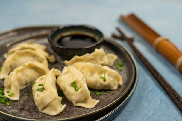 Gyoza or dumplings snack with soy sauce, selective focus, copy space.and chopsticks, top view. - Fotó, kép
