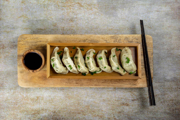 Gyoza or dumplings snack with soy sauce, selective focus, copy space.and chopsticks, top view. - Foto, immagini