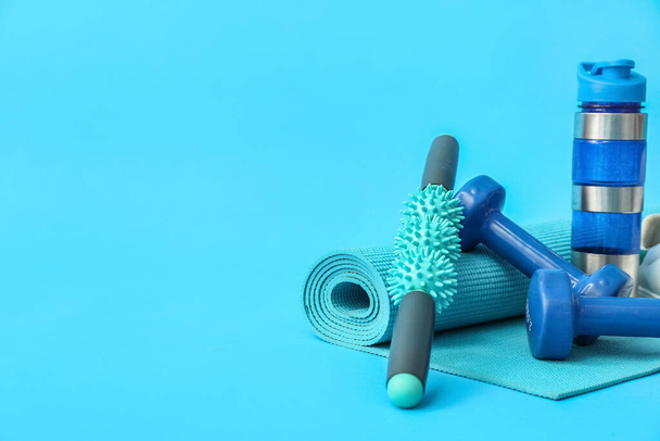 Set of sports equipment and bottle of water on color background - Foto, afbeelding