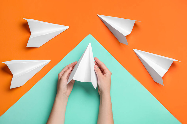 Woman with paper planes on color background - Foto, imagen
