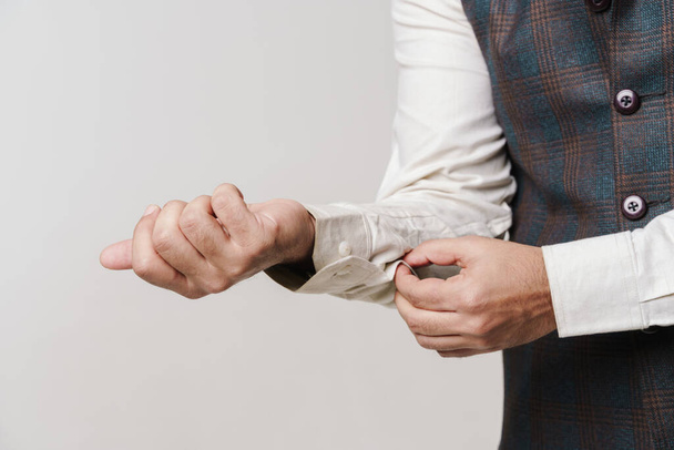 Photo of man's hands wearing shirt isolated over white wall - Photo, image