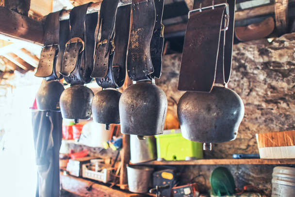 Some cowbells are various sizes in a barn - Photo, image
