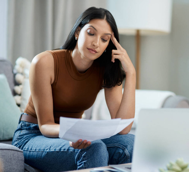 I overspent this month. an attractive young woman sitting alone in her living room and feeling stressed while calculating her finances - Fotoğraf, Görsel