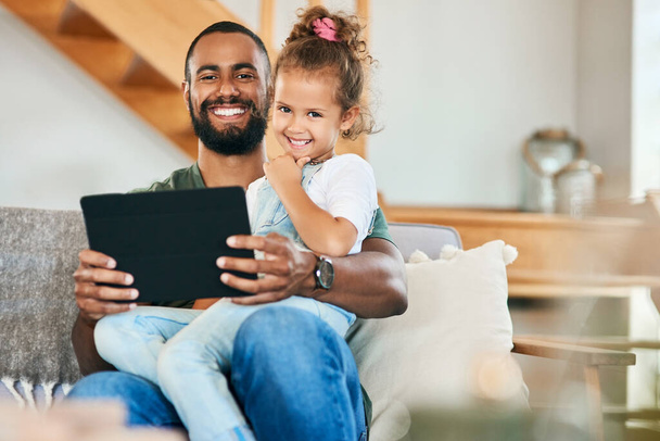 Discovering tons of educational videos and app for his little one. Portrait of a father and his little daughter using a digital tablet together at home - 写真・画像