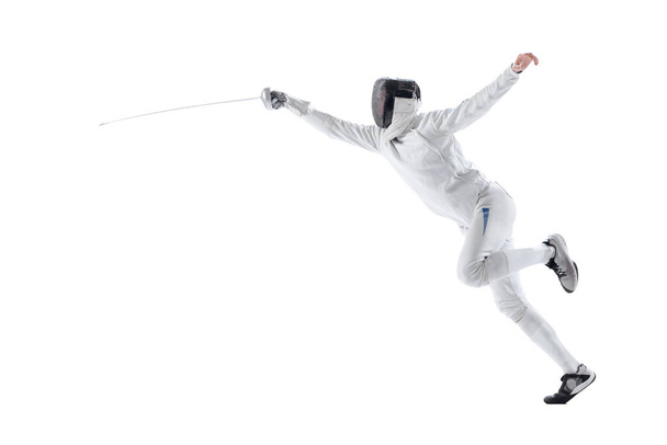 Thrust with rapier. Young man, fencer in in fencing costume with sword in hand training isolated on white background. Athlete practicing in motion, action. Copyspace for ad. Sport, energy, skills - Fotoğraf, Görsel