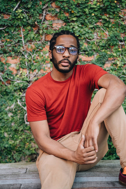 A portrait of young black man in red t-shirt and eyeglasses - Fotografie, Obrázek