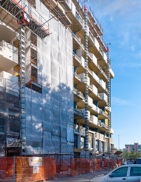 Scaffolding and protection nets on a condominium building affected by facade refurbishment works. Facade bonus tax deductions - Fotoğraf, Görsel